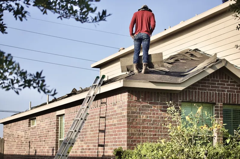 Professional roofer working on a residential roof in West Granby